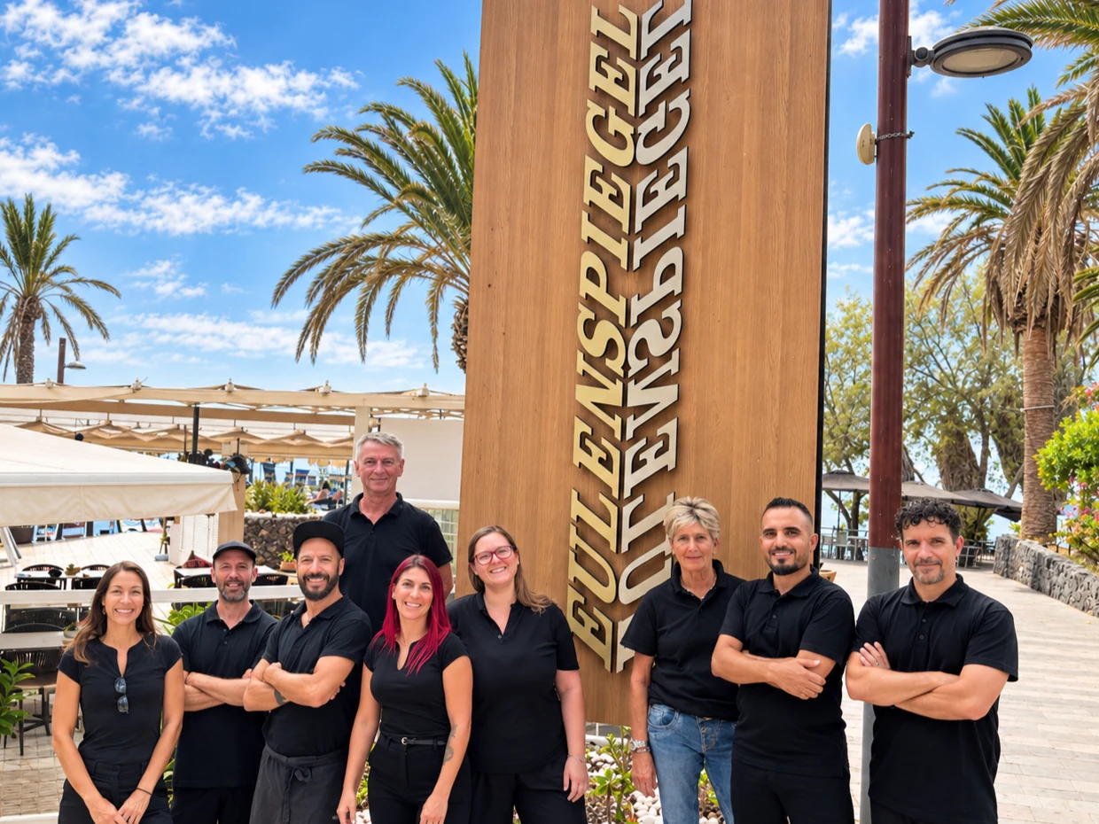 The Eulenspiegel Tenerife team beside the restaurant sign